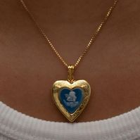 The Blue Angel Photo Locket Necklace This item is handmade to order. Please click the ‘SHIPPING’ bubble for more information on turnaround times. The locket is fully functional, with an option to include a photo! Metal: 18KT Gold Vermeil Chain type: Box Length: 16" total Locket Size: 0.75" NOTE: Please do not get your lockets wet or submerge them in water. As these items include paper goods, we will not be liable for any water damage that can ruin your photo. *Any items purchased with a discount