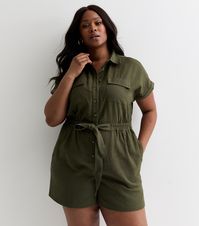 New Look Curves Khaki Cotton Utility Playsuit. Curves. Made from cotton fabric, this utility-style design will become your warm-weather wardrobe staple. Material: midweight cotton Fit: Curves, relaxed Length: over-the-knee mini  Colour: khaki Waist: elasticated Pockets: flap-front pockets Sleeves: rolled-up short sleeves Fastening: buttoned front Design: collar, front-tie detail Model: 5'10"/178cm and wears Curves UK 18/EU 36/US 4.