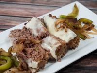 Philly cheese steak and meatloaf is a match made in heaven! Hearty meatloaf gets topped Philly-style with melted provolone, peppers and onions. Leftovers for sandwiches, anyone?