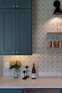 Perfect modern wet bar. Geomotric tile backsplash. Blue cabinets. Brushed nickle pulls. Floating shelves. Black scones lighting. White soild surface counter tops.