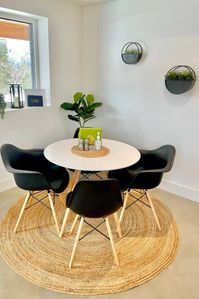 This small dining room set maximizes space with style! A sleek white round table pairs perfectly with black chairs for a chic and modern look. Round wall plant holders add a touch of greenery and soften the clean lines of the furniture. This space-saving design is perfect for small apartments or eat-in kitchens. #moderndiningroom #minimalistdining #rounddiningtable #blackchairs #wallplantholders #smalldiningroom #diningroomideas #interiordesign #homedecor #diningroomset #spac savingeating #kitchendining #roundtable #greenery