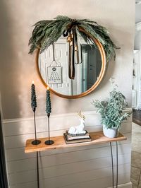 Cedar swag on round mirror in entryway. Tap to shop. #christmas #entryway #christmasdecor #mirror #candles #christmasideas #target #targetstyle #targetfinds