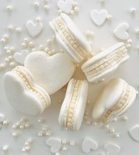 Our amazing Pearl White Macarons now come with a Heart Shape Design!  These little beauties are made by hand with lots of love and careful attention to detail. The gorgeous design featuring edible pearls and a white heart-shaped shell is going to make jaws drop. Your friends and family won't be able to believe how insanely pretty these macarons look! But it's not just about the looks. They come with our signature flavor options, classic Vanilla Bean, and fresh Lemon. Each bite packs a ton of flavor into these lovely French treats. Whether you want to surprise your loved one with a gorgeous treat or wow your guests with a showstopping dessert for a party, Heart-shaped Pearl White Macarons are the way to go. Elegant yet fun, they're a dessert you'll never forget! We proudly produce our macar