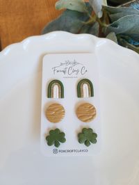 St. Patrick's Day stud pack including green, white, and glittery gold rainbows, round gold studs and of course, shamrock studs! Earring posts are stainless steel and embedded in UV resin or liquid clay for durability. Since each pair is made by hand, please allow for slight variations in color/design. Clay earrings are very durable, but try not to bend them too much or they may break. Clean with a wet cloth or use a small amount of alcohol and gently wipe. Avoid wearing in water.