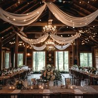 Featuring soft draped fabric, romantic chandeliers, and twinkle lights, this setup creates a warm and inviting atmosphere for your special day. Ideal for couples who love the rustic-chic aesthetic, this venue offers the perfect backdrop for a memorable celebration. Save this pin for inspiration on planning your dream rustic wedding! #RusticWedding #BarnWedding #TwinkleLights #WeddingInspiration #ElegantWeddings"