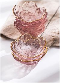 Discover the refined elegance of our exquisitely crafted glass saucers, designed to bring a touch of nature's beauty to your tableware collection. These delicate pieces, featuring a soft pink hue and a luxurious gilded edge, evoke the timeless charm of cherry blossoms in full bloom. With a diameter of approximately 8 cm, these versatile saucers are perfect for presenting a variety of culinary delights, from savory sauces to enticing nuts and other small snacks. Envision your creations elegantly