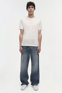 PRE-FALL 2024 MEN'S COLLECTION The Poe Jeans in Vintage Wash. Featuring a relaxed fit through the hips and thighs, these jeans flare out to a wide leg for an effortlessly cool and contemporary look. This classic design and versatile wash make them a stylish addition to any wardrobe.