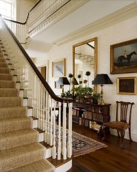 Dark wood, a gilded mirror, black lamp shades and persian rug runner all make this a lovely traditional entryway.