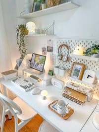 This clean and minimalist white workspace is perfect for staying organized and inspired. With a tidy desk layout, soft lighting, and adorable decor elements like a small cat lamp and wooden accessories, this setup balances simplicity with a touch of personality. The pegboard on the wall helps keep essentials within reach, and the floating shelves add more storage for decor and plants. Whether you're working or studying, this space provides a peaceful environment for creativity and focus. Save this pin to create your own cozy workspace!