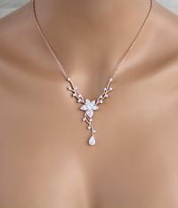 "Dainty Rose gold Bridal backdrop necklace and earrings set. Created in a lovely vine floral design that sparkles with Swarovski Pure Brilliance stones - Necklace measures 16 inches and extends to 18 inches - Backdrop measures 9 inches - You can choose a removable backdrop option in the drop down menu. This gives you an option to be able to wear the necklace alone without the backdrop. - Earrings dangle 1-3/8\" - Rose gold finish - Swarovski Pure Brilliance stones - Nickel free - Available in ro