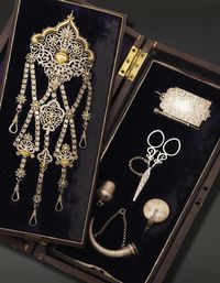 Antique silver chatelaine, consisting of a thimble holder, a vinaigrette designed as a trumpet, a watch case, scissors, and notebook, decorated with flowers and foliage, 19th century, gross weight: 265 g