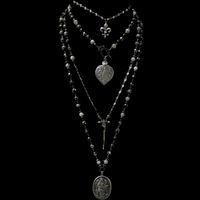 The  Lujan Choker features an intricately carved Our Lady of Lujan medal within a flaming  Sacred Heart made of Sterling Silver.  She's surrounded by Angels, with two of them raising a crown of flowers above her.  Pilgrims worldwide travel to see Her and have received special graces, favors and miracles.   The gunmetal