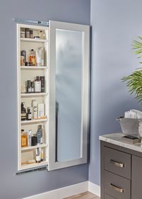 Got plans to hang a mirror or a large painting? Consider using the stud cavity behind it for handy, secret storage. I installed this mirror cabinet in the bathroom — like a giant medicine cabinet. The mirror glides on ball-bearing drawer slides to open and close the cabinet. When the mirror is in place, nobody knows the cabinet is even there!