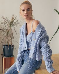 A sweater set from Andamane and high-waisted jeans make for a chic nod to the '90s while still looking effortlessly modern. Featuring a light blue chunky cable knit design and cozy cashmere blend, this crop top and matching button up cardigan make for the perfect combination.