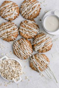 These white chocolate oatmeal cookies are super chewy and loaded with white chocolate. They are topped with a deliciously tangy cream cheese glaze. They are easy to make from scratch and would be amazing to add to a holiday cookie swap or to have for breakfast with company! #oatmealcookies #whitechocolateoatmealcookies #holidaycookies #whitechocolate #frostingandfettuccine #cookies #chewycookies #whitechocolateoatmealcookies #creamcheeseglaze