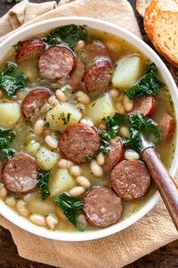 This sausage soup is rich and cozy, brimming with hearty ingredients such as beef smoked sausage, diced potatoes, white beans and kale! | thecozyapron.com #sausagesoup #sausagesouprecipes #sausagesouphealthy