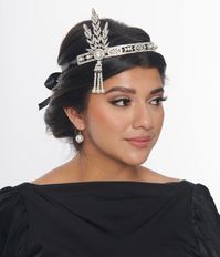 This exquisite 1920s inspired black self-tie satin ribbon headpiece, in collaboration with The Great Gatsby, is adorned with an intricately designed silver rhinestone detail and elegant faux pearl drops, perfect for adding a touch of luxurious opulence to any ensemble.