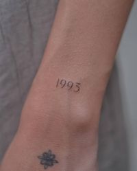 "1993" lettering tattoo located on the wrist.