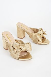 We love the flirty look of the Lulus Dorothea Gold Knotted High Heel Sandals! Metallic, pleated fabric shapes these adorable heels with a knotted bow atop the open toe upper and a sturdy block heel. Easy to wear, slide-on design. 3. 5" wrapped block heel. Cushioned insole. Felted, nonskid rubber sole. All Man Made Materials. Imported. Lulus | Dorothea Gold Knotted High Heel Sandal Heels | Size 5.