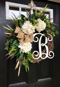 Gorgeous Elegant Year Round Door Wreath! Perfect for greeting your guests to your home with this one of a kind door wreath. Made up on an 18 grapevine wreath with moss, mixed flowing greenery of ivies, boxwood, eucalyptus, hydrangeas leaves, ficus leaves, green hops and ferns. Beautiful cream hydrangeas with white accents. A decorative 12 ivory script monogram and beautiful burlap bow make this wreath one of a kind. Measures approx: 28 x 25 x 7( tip to tip). Choose the letter you would lik...