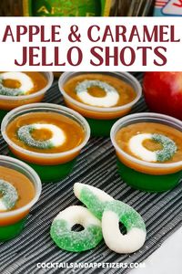 Perfect for Friendsmas and Christmas, these Caramel Apple Jello shots are made with Apple Whiskey, green apple jello and caramel sauce with a gummy candy ring garnish! Easy recipe for party jello shots.