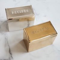 This heirloom-quality recipe box has a hinged lid featuring beautifully etched lettering to denote its purpose. 6.25” x 3.5” x 5.25” made of solid brass available in brass or silver-plated brass sold individually will have slight variations in design and size as this is a one-of-a-kind handmade product PLEASE NOTE: these handmade items are perfectly imperfect and due to their handmade nature, it is not uncommon for them to have minor imperfections Meet the Artisans Made from the skillful work of