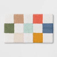 Bring a pop of color to their bath space with this Checkered Bath Rug from Pillowfort™. This medium-pile bath rug is made from 100% tufted cotton fabric to feel soft and provide cozy comfort underfoot. Showcasing a multicolor checkered print, it's sure to add fun style to their bathroom decor.