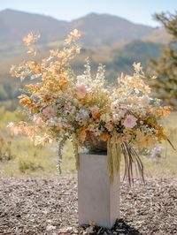 White delphinium, cafe au lait dahlia, fall foliage, peegee hydrangea, green hanging amaranthus, blush spray rose, chocolate lisianthus, chocolate lace, butterfly ranunculus, fountain grass ceremony altar urn flowers