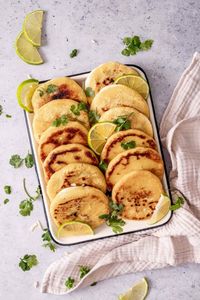 pupusas with curtido in a white pan.