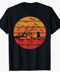 Silhouette of a little black cat sitting far out on a spindly tree branch, watching the bats as a distressed red-orange sun sets on Halloween.