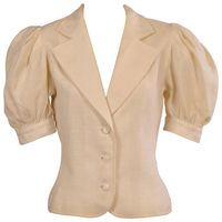 Creamy white linen is used for this feminine version of a blazer. YSL has nipped in the waist and added short full sleeves to achieve a fresh summer look. The jacket is marked a size 34 and it is in excellent condition. Measurements; Shoulders 13.5" Bust 36" Waist 30" Sleeve 13 Length 20"