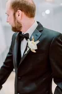 Groom boutonniere | simple modern wedding | white ranunculus | italian ruscus | simple boutonniere | wedding inspiration | Milwaukee wedding | Wisconsin wedding florist | wedding ideas | elegant wedding | groom inspo | wedding tux | all black wedding attire | groomswear | wedding portrait | ranunculus boutonniere | wedding party | 2021 wedding | 2022 wedding | wedding planning | WI wedding | NYE wedding | winter wedding |