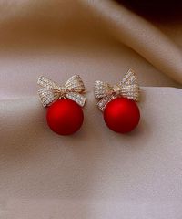 Red Imitation Pearl & Crystal Bow Stud Earrings. A richly hued imitation pearl stars on these stud earrings accented with crystal bows to give your look a dash of polished glamour. 0.5'' W x 0.7'' HGoldtone brass / imitation pearl / glass crystalImported