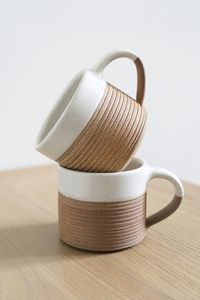 The Mali Ribbed White & Terracotta Mug from Nkuku features a ribbed finish that provides a contemporary feel and stylish look. Boasting a contrasting two-tone design with an off-white top half and lower natural terracotta base. Skilfully handmade with a wonderful tactile finish. Seconds: Please note, seconds are reduced in price due to slight markings/imperfections in the terracotta. This doesn't affect the use of the item.