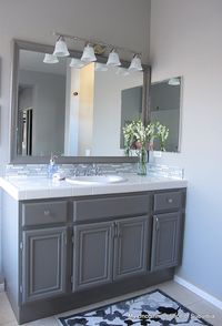 Large mist proof mirror over basins with lighting from above if it is possible to remove pillar between basins? If not then a medicine cabinet on the wall above each basin.