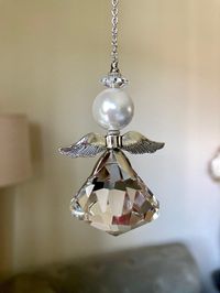 "30mm Cone shape crystal glass sun crystal angel pendant hanging ornament. Ornate with a 12mm white shell pearl and a silver plated wing. 10\" long from hook to bottom. Hand made! All purchase will arrive in gift boxes. Thanks for stopping by!"