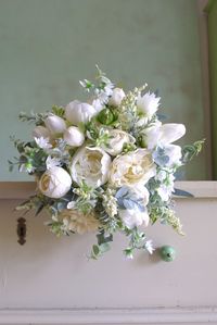 An elegant wedding bouquet in an immortal white-cream combination is made of textile flowers of dahlias, spiers, peonies, tulips and milkweeds. All flowers are carefully selected to look as alive.