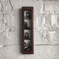 This our Mid Century Modern inspired Solid Walnut Picture Frame .  This fits a 1.5" x 8" photobooth strip. Made of FSC sustainably harvested solid American black walnut with a zero voc eco friendly danish oil to make a rich dark walnut color with a beautiful matte  finish. Use the folding tab to hang by mail or sawtooth hanger for walls, or use the built in magnets to hang on your refrigerator.  Protected by PETG plexiglass with engraved recycling logo that can be recycled by Terracycle.  To dis