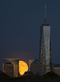 A full harvest moon rises behind Lower Manhattan and One World Trade Center in New York City on September 16, 2016