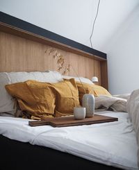 Scandinavian bedroom with black wall and wooden headboard via Only Deco Love