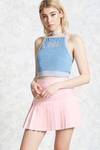 A woven mini skirt featuring pleated drop-waist construction and a concealed back zip closure.