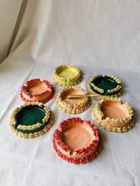 "Ceramic Cake Ashtrays includes a 3 different color combos: Pink ashtrays features a light pink base with darker pink \"frosting\" and 4 indentations.  Mint ashtrays features a mint base with white \"frosting\" and 4 indentations.  Teal ashtrays features a teal base with white \"frosting\" and 4 indentations.  Ashtrays are dishwasher safe, however we do recommend hand washing and drying them.  Dimensions- approx. 4inches diameter, approx. 1.5inches tall Weighs Approx. 11-12oz"