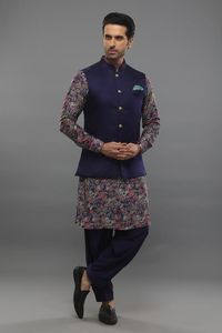 Purple spun silk kurta with floral print. Comes with muslin salwar and a satin linen bundi. Components: 3 Pattern: Printed Type Of Work: Floral Neckline: Mandarin collar Sleeve Type: Kurta : Full, Bundi : Sleeveless Fabric: Kurta : Spun silk, Bundi : Satin linen, Salwar : Muslin Color: Purple Other Details:  Closure : Bundi - Front buttons Note : Pocket square shown in the images is not for sale. Outfit worn by the boy child model is not for sale. Occasion: Mehendi and Puja - Aza Fashions