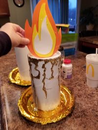 Lumiere hands mad from oatmeal containers a paper plate covered in gold duct tape from the Dollar store.  Flame is craft foam