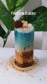 Salted caramel iced latte inspired by the ocean!  A fun summer drink to celebrate the season and feel like you're relaxing on the beach. Top with a chocolate seashell or starfish to really tie in the whole aesthetic!  To get the blue liquid, combine hot water and butterfly pea tea.  Ingredients  • 2-3 pumps caramel sauce  • 2 pinches of salt  • 1 shot of espresso  • 1/2 c oat milk  • 1/4 c butterfly pea tea  • whipped cream  • crushed graham crackers  • seashell chocolate (optional)