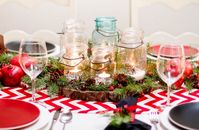 glass jars on a wood slice decorated with evergreens