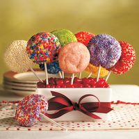 To bake these adorable cookie pops, simply roll balls of sugar cookie dough in colored sprinkles and insert a white craft stick before baking. Make a colorful (and edible) centerpiece for the kids' table by filling a container with florist foam, topping it with jelly beans, and then sticking the pops into the foam.