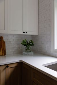 wood stained lower cabinets, black hardward, white soapstone coutnertops, white tile backsplash, painted white upper cabinets, undermount sink, elevated, organic, kitchcen