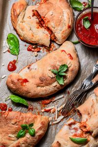 These vegan calzones feature golden-brown homemade pizza dough that wraps around a rich filling of gooey dairy-free mozzarella, plant-based pepperoni, and Italian-seasoned peppers and onions. Each bite brings together a rich blend of savory, Italian-inspired flavors that both vegans and non-vegans will love! These make a great vegan and vegetarian lunch, dinner or back to school snack.