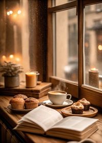 Immerse yourself in the ultimate cozy vibes with a warm cup of coffee, freshly baked muffins, and an open book by the window. Perfect for slow mornings or a peaceful escape into your favorite read. ✨ Create your own hygge moment today! Hashtags: #CozyVibes #CoffeeTime #BookLovers #HyggeLife #CafeAesthetic #FallFeels #ComfortFood #WarmAndInviting  Keywords: Cozy café, warm drinks, coffee, muffins, cupcakes, open book, candlelight, hygge, cozy ambiance, rainy day, reading nook, fall vibes, rustic aesthetic, comfort food, peaceful retreat.